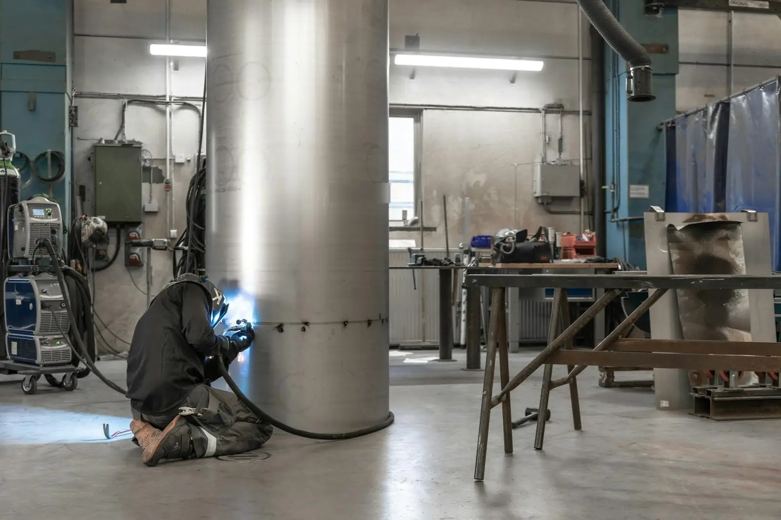 Welder fabricating a cylindrical steel shell